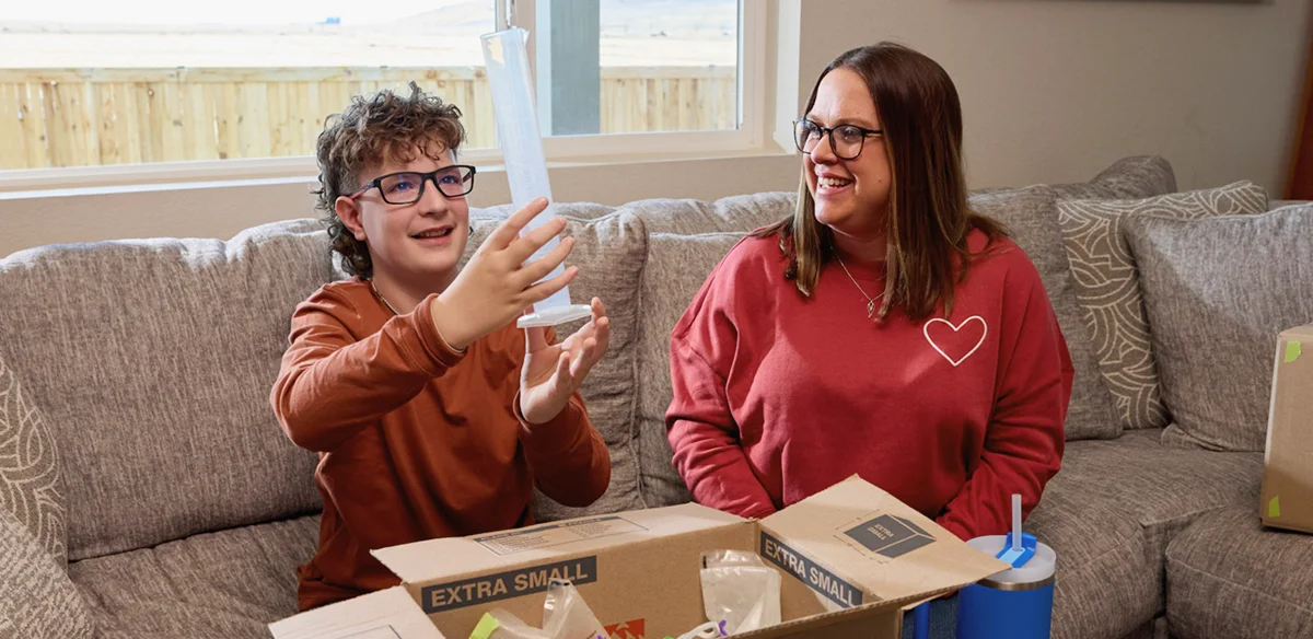 Mother and son opening together a box of school supplies